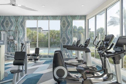 a gym with a pool and workout equipment in front of windows at Lakeside Villas, Orlando, 32817