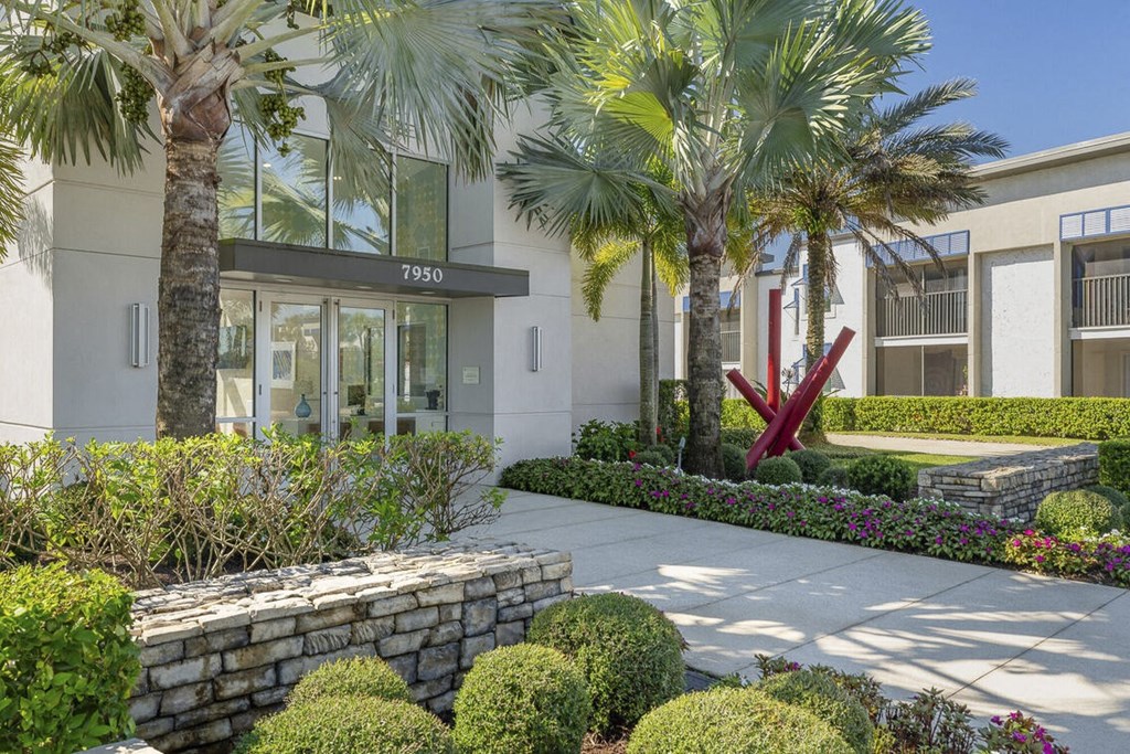 a building with palm trees and a sidewalk in front of it at Lakeside Villas, Orlando, FL