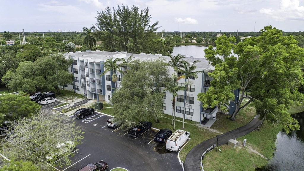 an aerial view of a large white apartment complex with a river in the background  at Club at Emerald Waters, Hollywood, 33021
