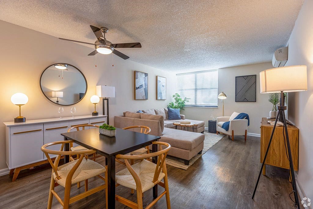 a living room and dining area with a ceiling fan and a large mirror  at Club at Emerald Waters, Hollywood, FL