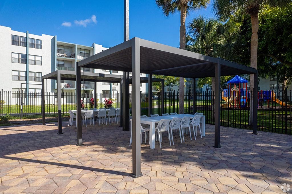 a covered patio with tables and chairs  at Club at Emerald Waters, Hollywood, FL, 33021