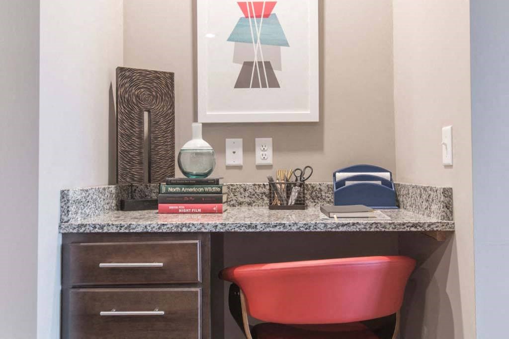 a desk with a chair and a painting on the wall