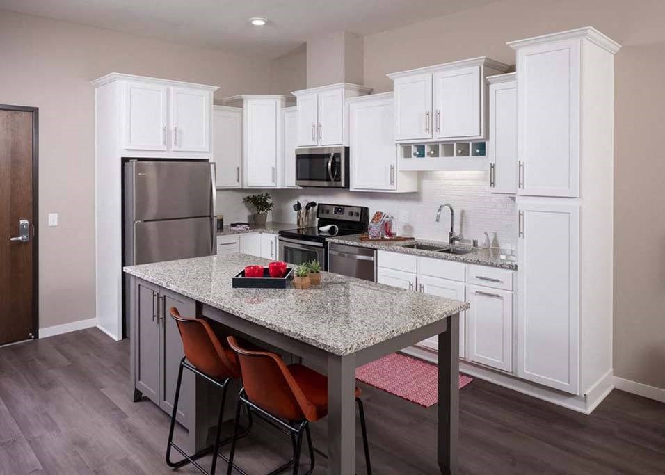 a kitchen with white cabinets and a granite counter top