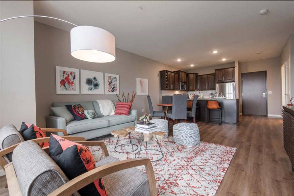 a living room with furniture and a kitchen in the background