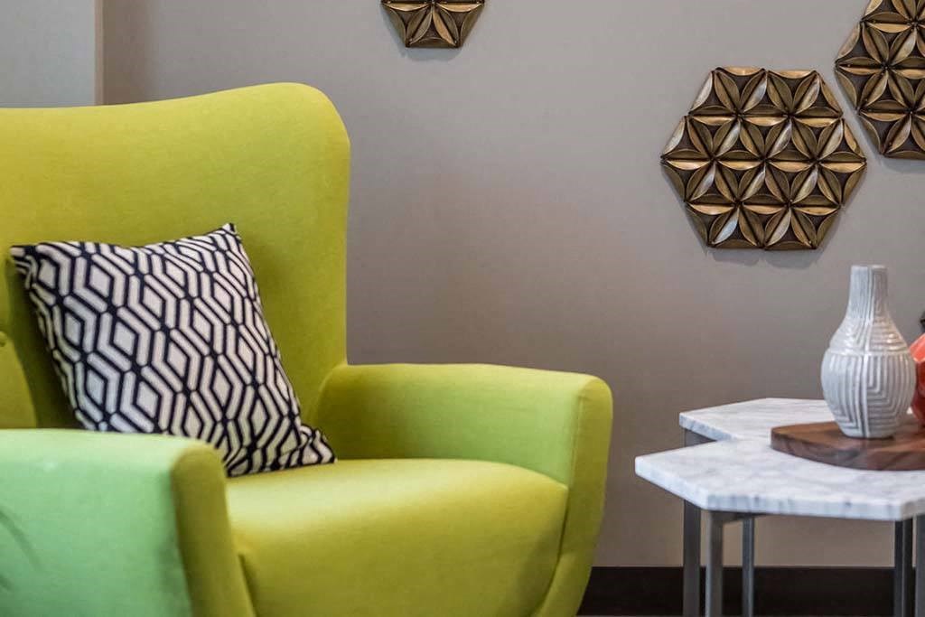 a green chair sitting next to a white table
