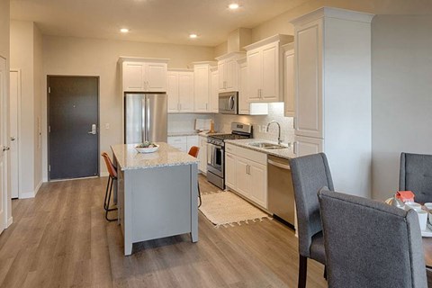 a large kitchen with a table and a refrigerator