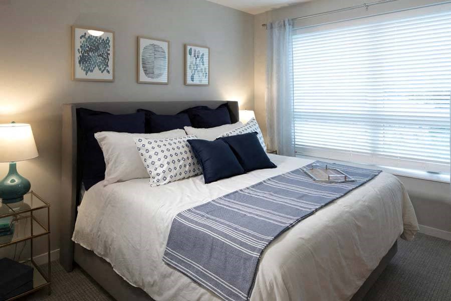 a bedroom with a large bed next to a window