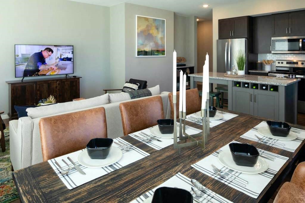 a living room with a table and chairs and a television in the background