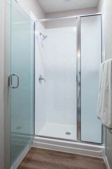 a bathroom with a glass shower stall and a white towel