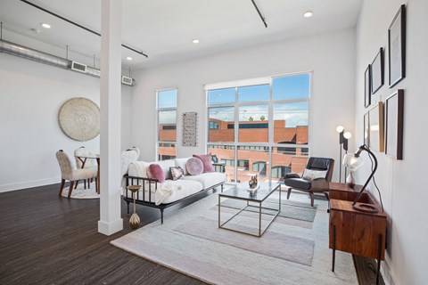 A living room with a white sofa and a glass coffee table.