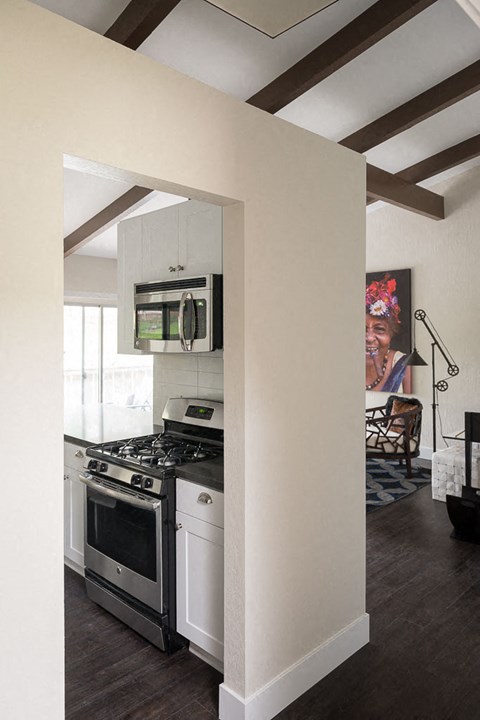 A kitchen with a stove top oven and a microwave above it.