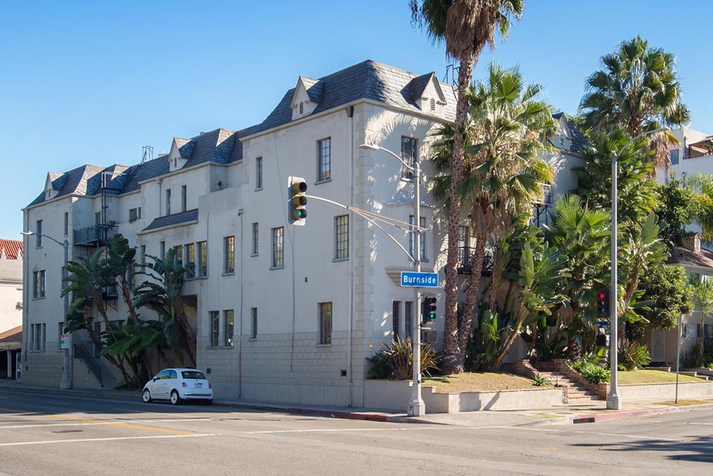 a white building on the corner of a street with a traffic light