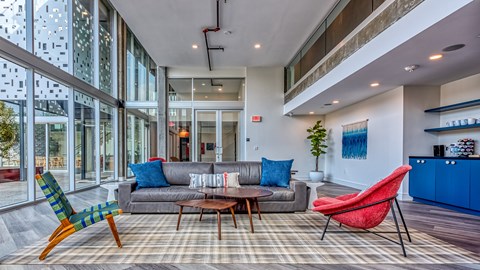 A living room with a grey couch, a red chair and a blue chair.