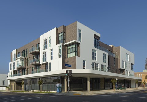 A modern multi-story building with a mix of white and brown exterior.