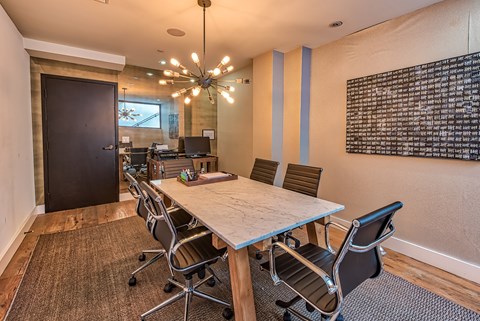A conference room with a long table and chairs.