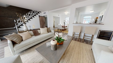 A living room with a white couch and a wooden coffee table.