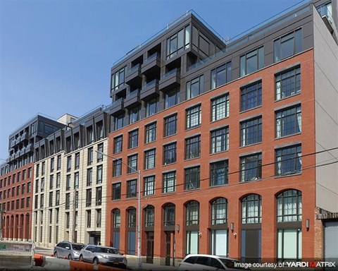 a tall brick building with cars parked in front of it
