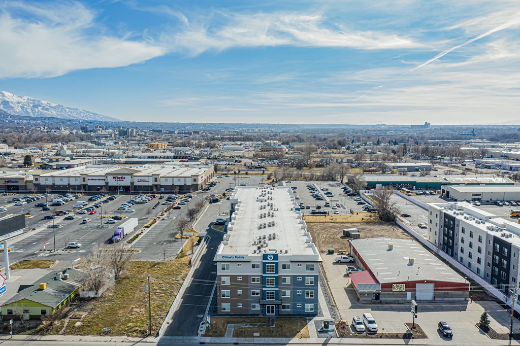 an aerial view of a city with cars parked in a parking lot