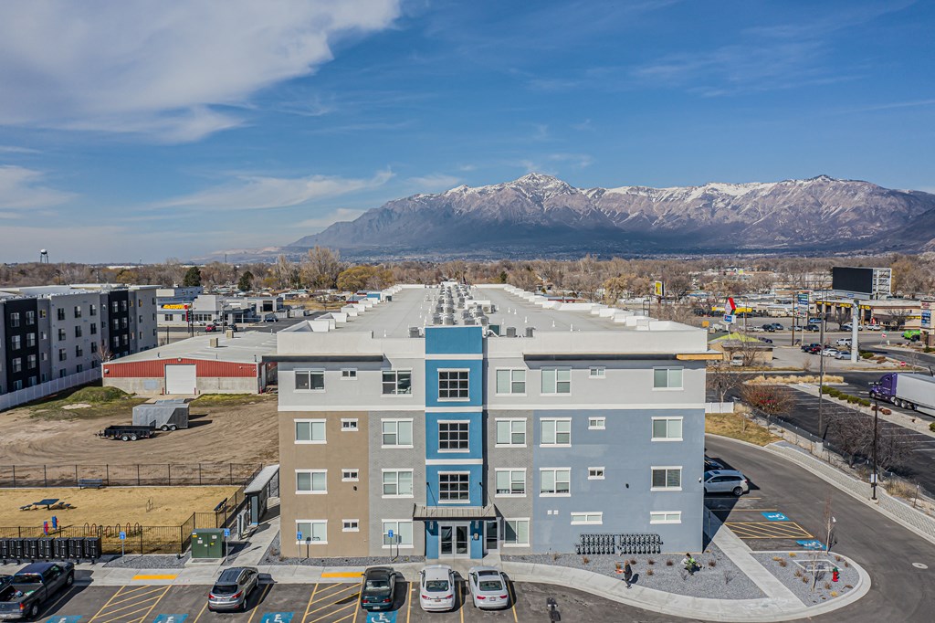 a large apartment building with mountains in the background