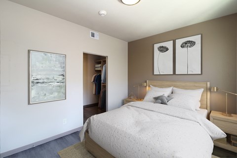 a bedroom with a bed and two paintings on the wall