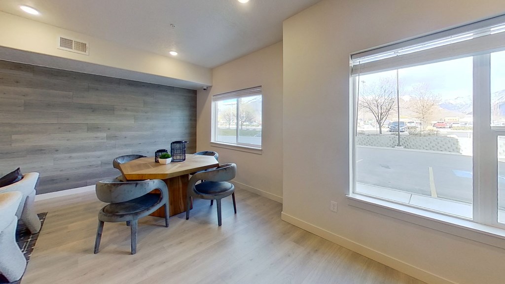 a dining room with a table and chairs and a large window