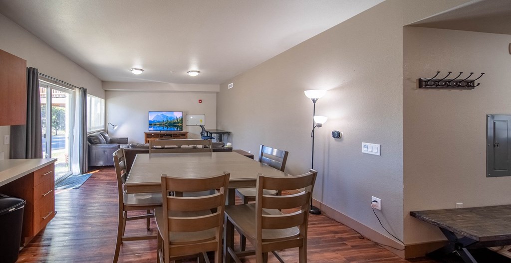 A kitchen with a dining table and chairs.