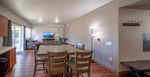 A kitchen with a dining table and chairs.