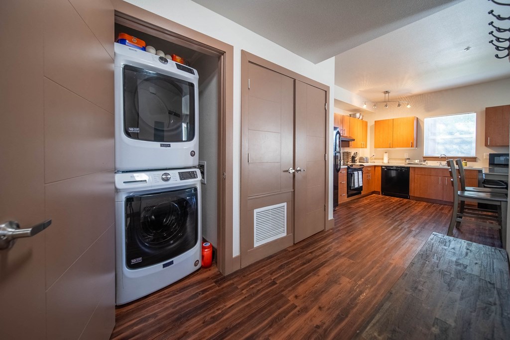 A modern kitchen with a white oven and wooden floors.