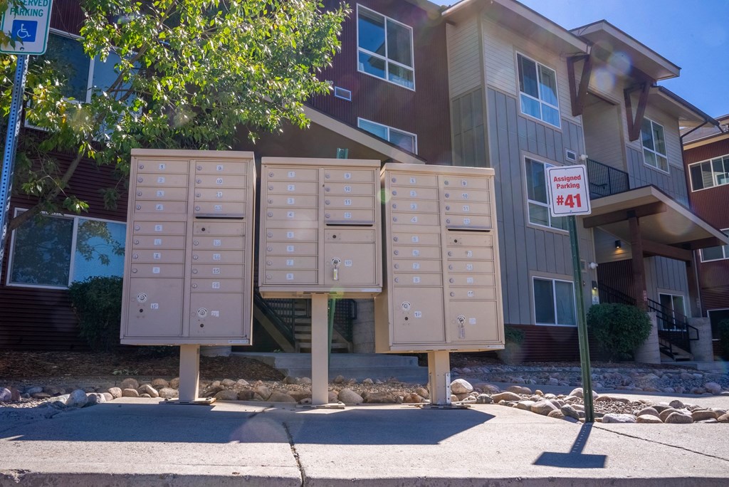 A row of mailboxes in front of apartment buildings.