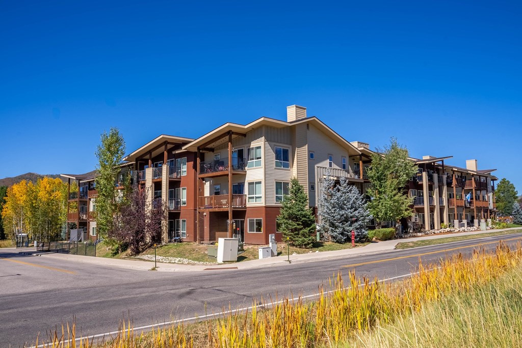 A large apartment complex with a parking lot in front.