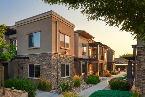 a row of townhouses with a sidewalk in front of them