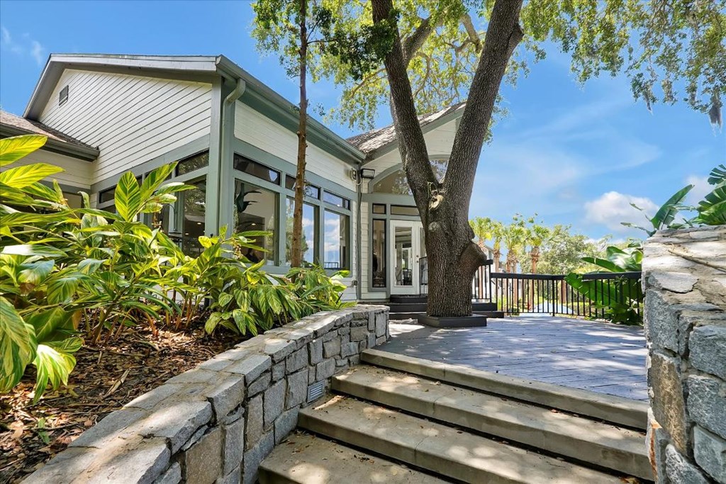 a house with stairs and a tree in front of it