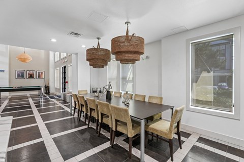 A dining room with a long table and chairs.