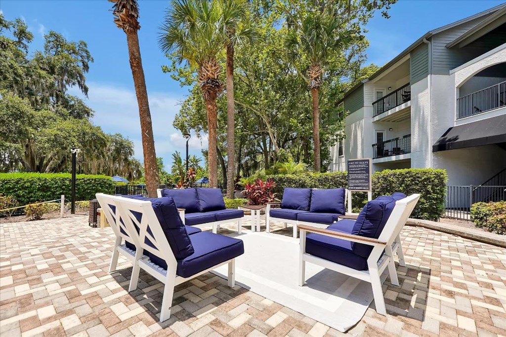 a patio with chairs and a table in front of a building