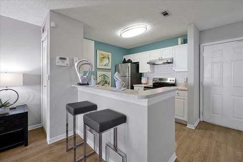 a kitchen with a counter top with two stools