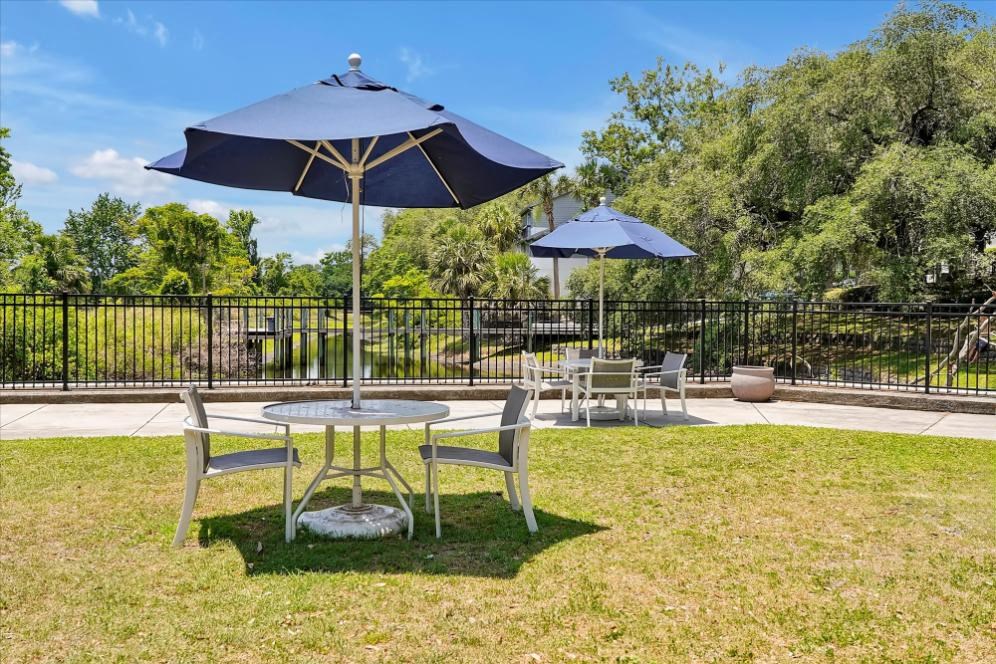 a picnic area with tables and umbrellas on the grass