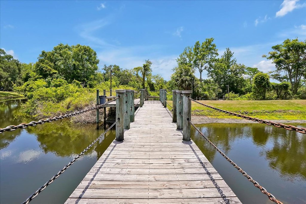 a wooden bridge over a river with chains