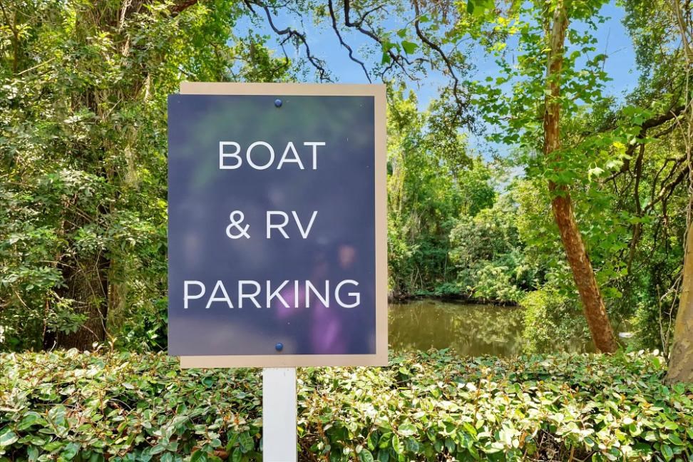 a boat and rv parking sign in front of a pond