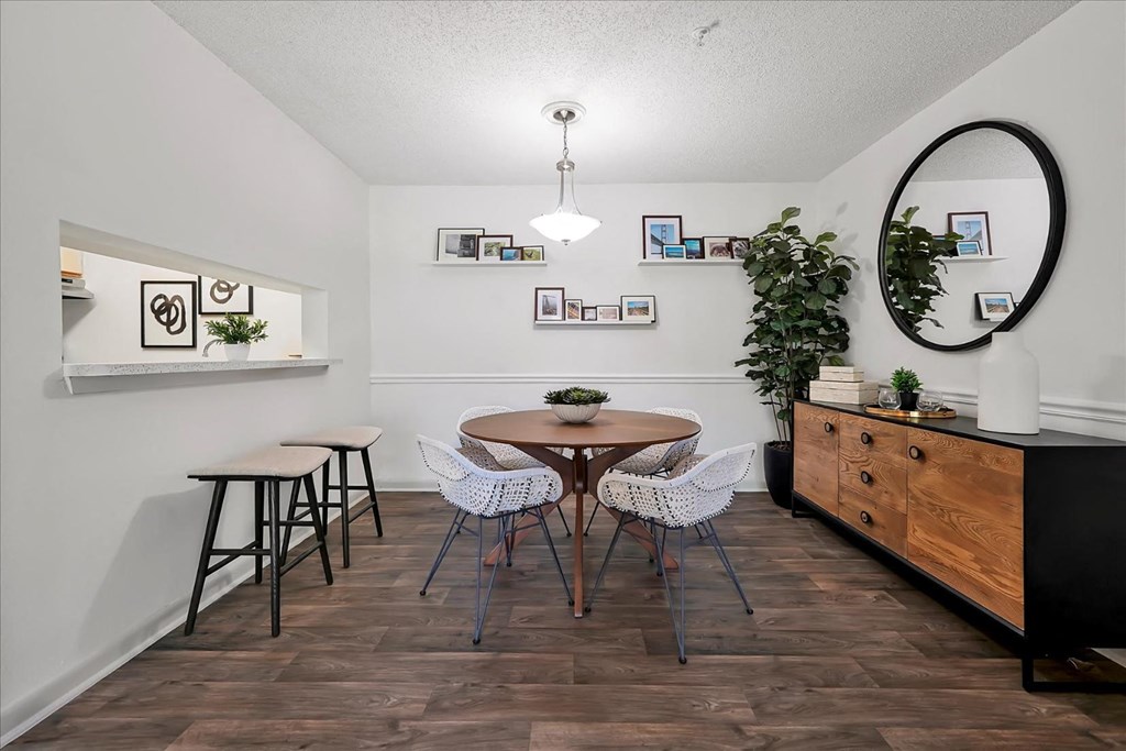 a dining room with a table and chairs and a mirror