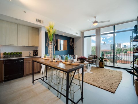 a kitchen and living room with a large window and a table