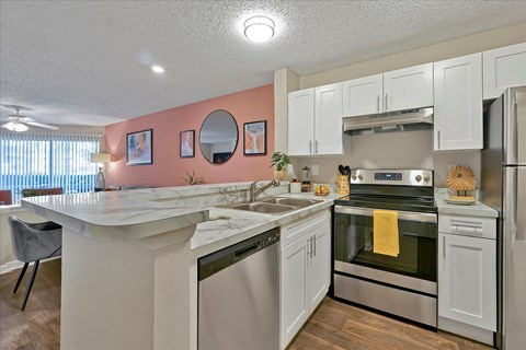 a kitchen with white cabinets and appliances and a counter top