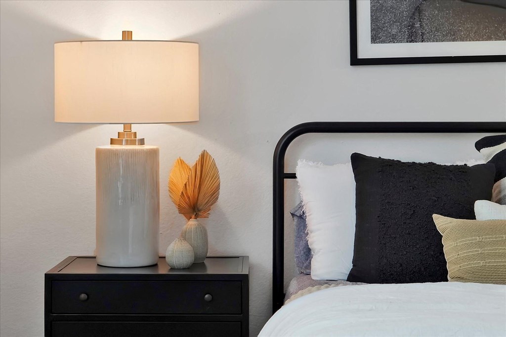a bedroom with a bed and a night stand with a lamp