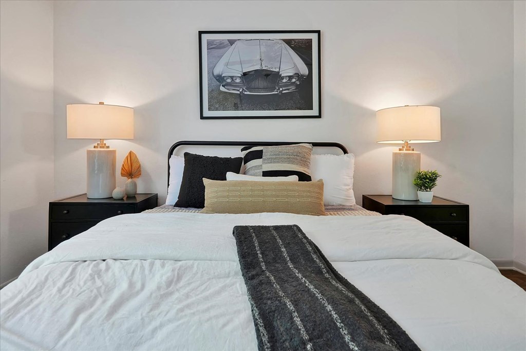 a bedroom with a bed and a picture of a boat on the wall