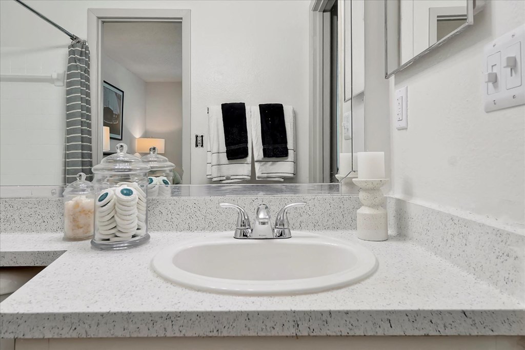 a white bathroom with a sink and a mirror