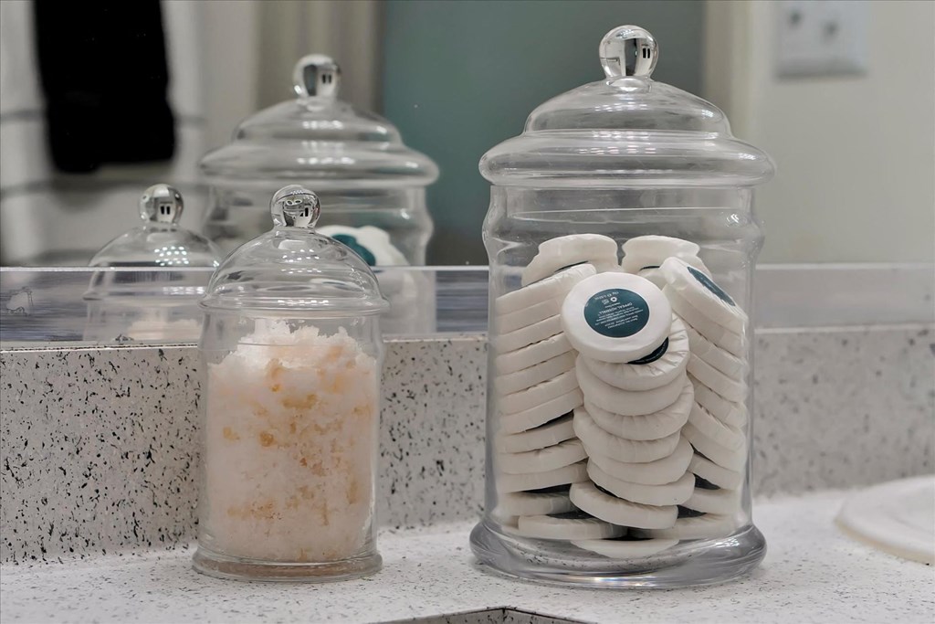 a pair of glass jars filled with peeledumbers on a bathroom counter