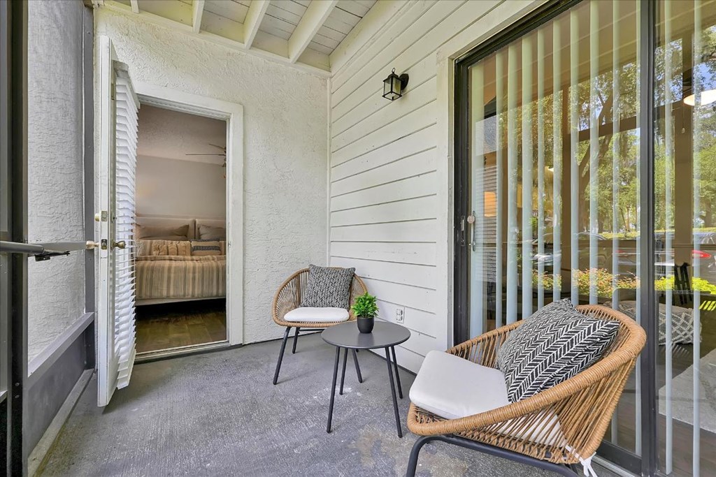 a small porch with two chairs and a table