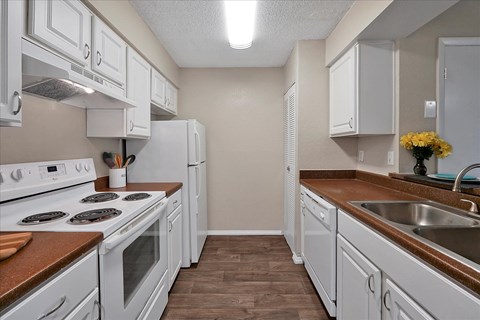 a kitchen with white appliances and counters and white cabinets