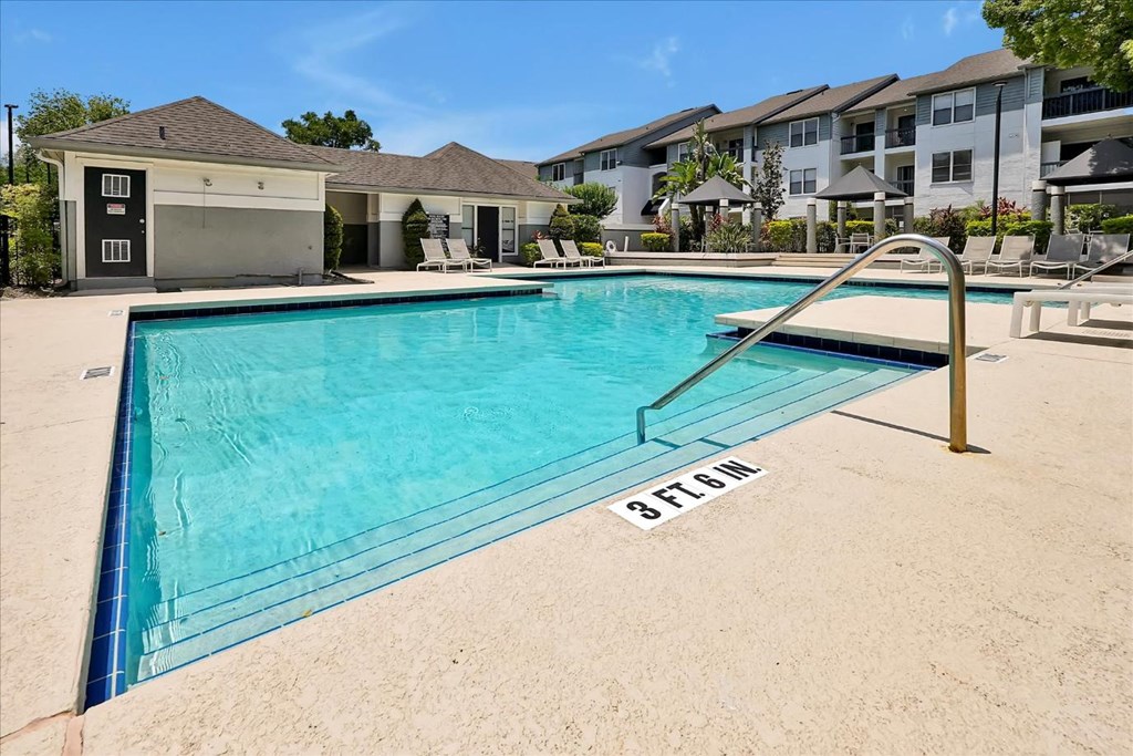 a swimming pool with an apartment building in the background