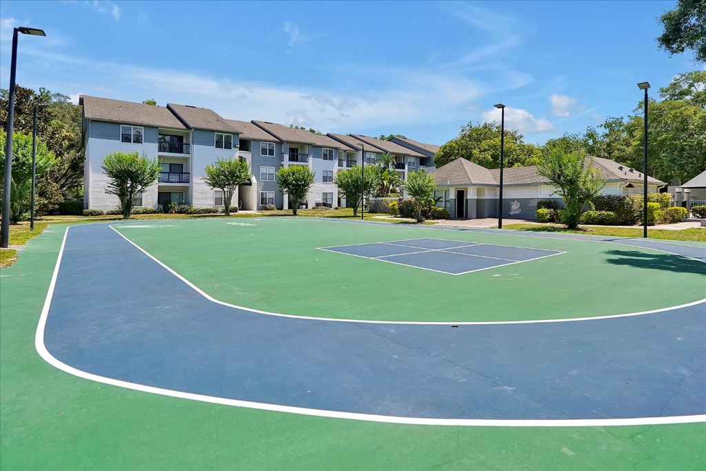 a tennis court with apartments in the background