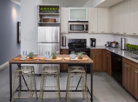 a kitchen with a center island with bar stools and a stainless steel refrigerator
